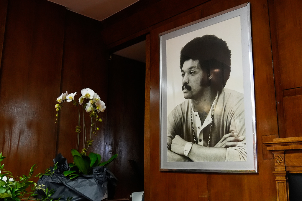 White orchids sit on a table next to a framed photo of Rev. Jesse Jackson during a public visitation for him at Rainbow PUSH Coalition headquarters Friday, Feb. 27, 2026, in Chicago. (AP Photo/Erin Hooley)
