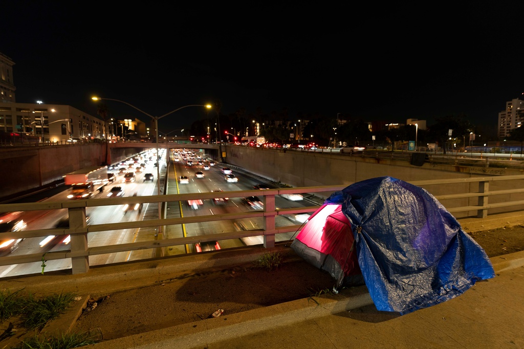 FILE - A tarp covers a portion of a homeless person's tent on a bridge overlooking the 101 Freeway in Los Angeles, Feb. 2, 2023. (AP Photo/Jae C. Hong, File)