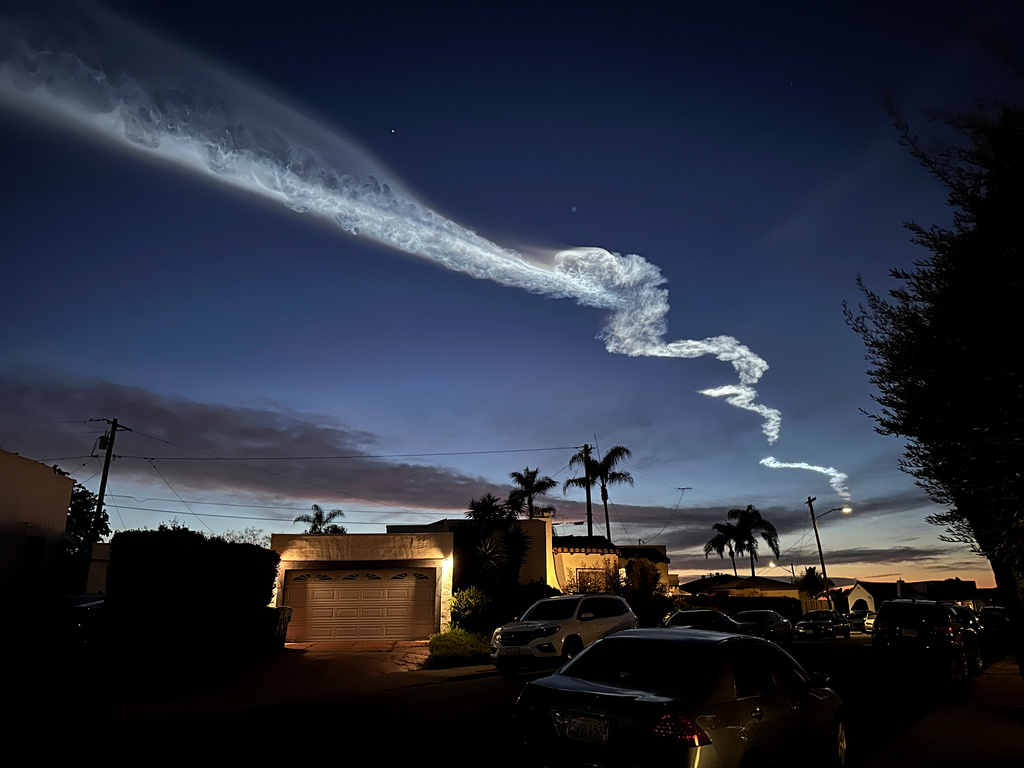 FILE - A contrail from a SpaceX Falcon 9 rocket, which launched from Vandenberg Space Force Base, is seen over homes March 18, 2024, in San Diego. (AP Photo/Gregory Bull, File)