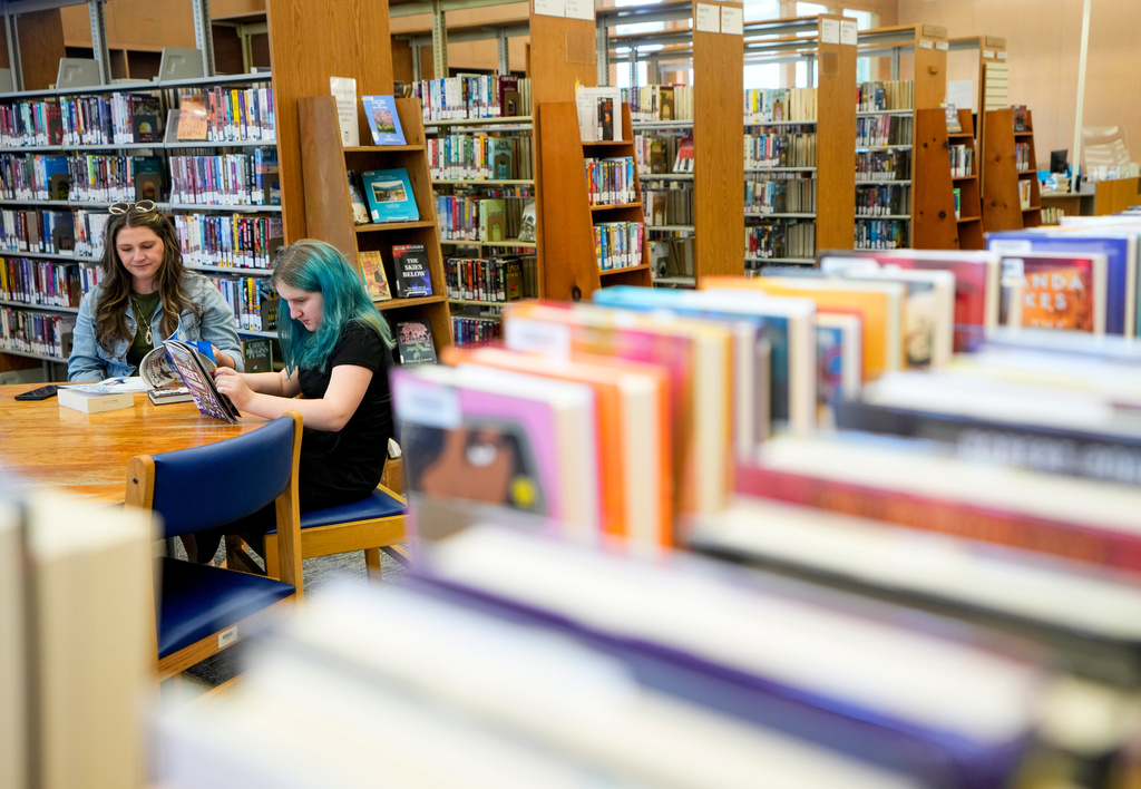 FILE - A mother and daughter read at the Josephine Community Library in Grants Pass, Ore., on May 18, 2023. (AP Photo/Lindsey Wasson, File)