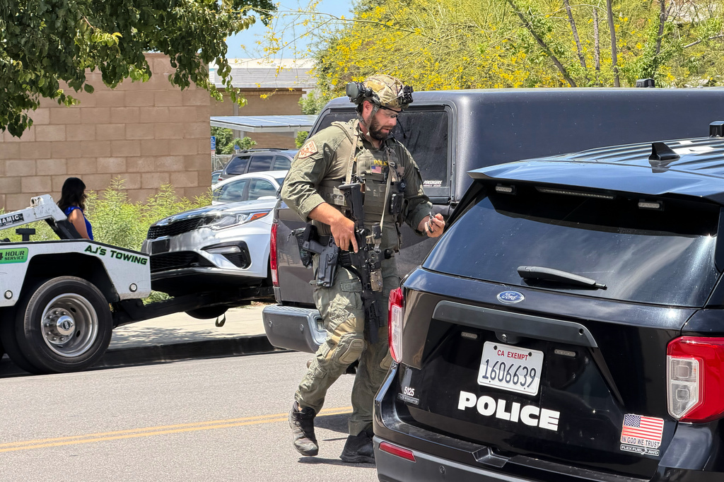 A law enforcement officer responds near a bank where a man barricaded himself on Tuesday, June 2, 2026, in Bakersfield, Calif. (Jacob, Dad’s Gone Live via AP)