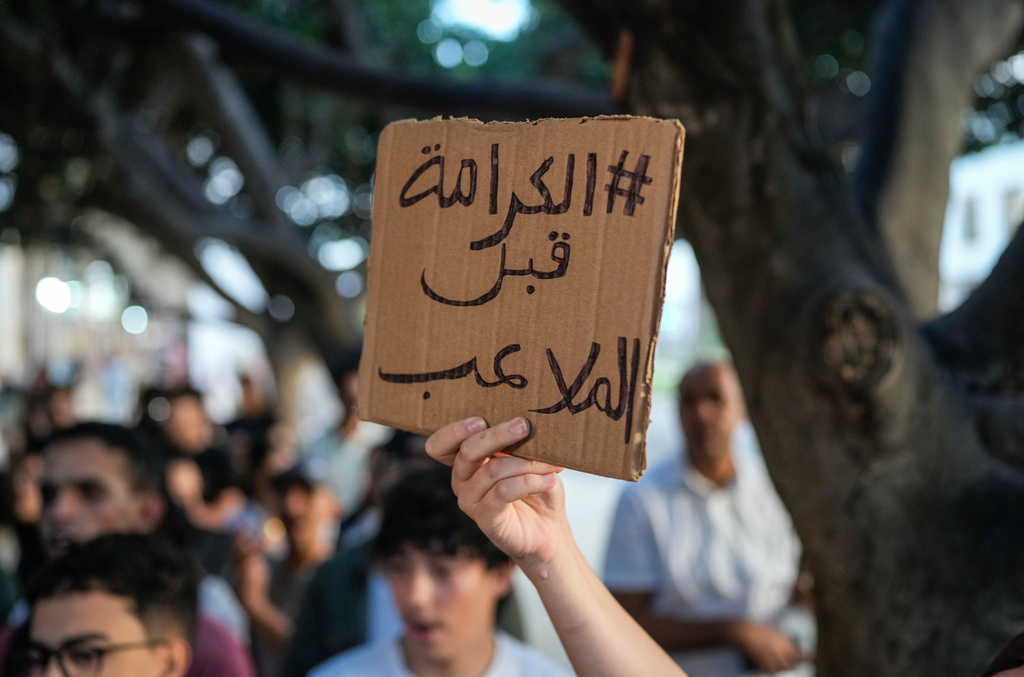 People take part in a youth-led protest against corruption and calling for healthcare and education reform in Rabat, Morocco, Friday, Oct. 3, 2025. The sign reads, "Dignity before stadiums." (AP Photo/Mosa'ab Elshamy)