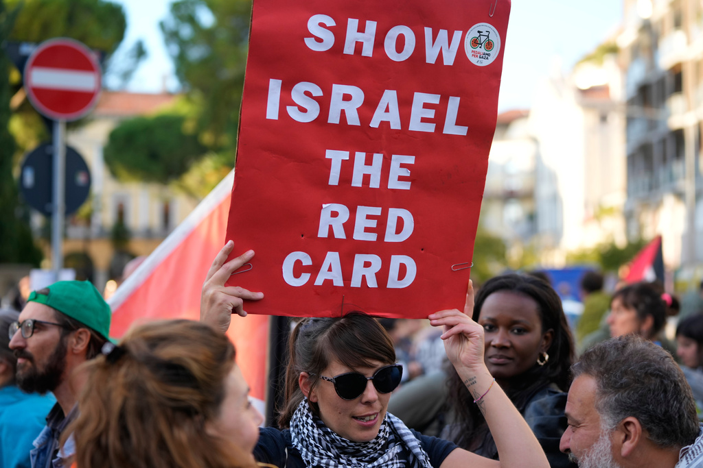 People protest against the participation of the Israeli national team in the 2026 Soccer World Cup qualification match against Italy being played in the evening in Udine, Italy, Tuesday, Oct. 14, 2025. (AP Photo/Luca Bruno)