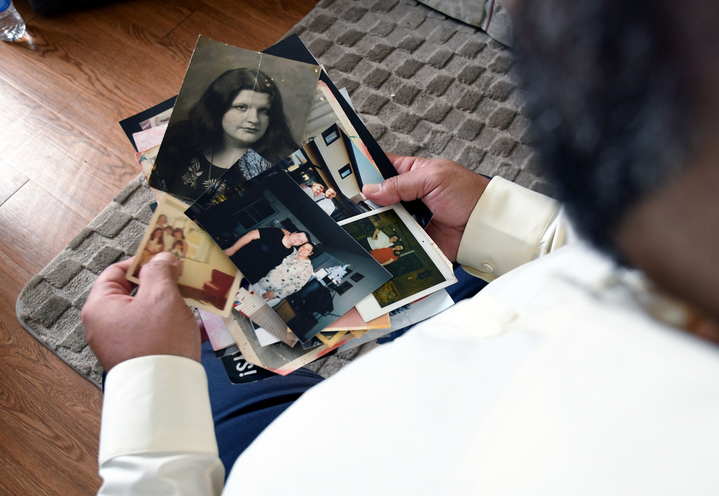 Derrick Johnson, whose mother's body was one of 189 left to decay in the Return to Nature Funeral Home in Penrose, Colo., holds photos of her in Colorado Springs, Colo., on Thursday, Feb. 5, 2026. (AP Photo/Thomas Peipert)