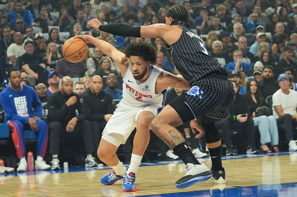 Detroit Pistons guard Cade Cunningham, left, tires to get past Orlando Magic forward Paolo Banchero, right, during the first half in Game 6 of a first-round NBA basketball playoffs series, Friday, May 1, 2026, in Orlando, Fla. (AP Photo/John Raoux)
