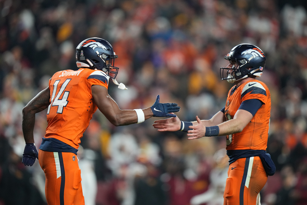 Denver Broncos wide receiver Courtland Sutton (14) celebrates after catching a touchdown pass from quarterback Bo Nix, right, during the first half of an NFL football game against the Washington Commanders Sunday, Nov. 30, 2025, in Landover, Md. (AP Photo/Stephanie Scarbrough)