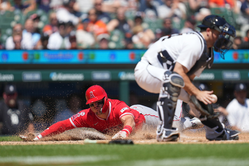Los Angeles Angels' Mike Trout, left, slides safely into home plate as Detroit Tigers catcher Jake Rogers (34) receives the throw during the eighth inning of a baseball game Thursday, May 28, 2026, in Detroit. (AP Photo/Paul Sancya)