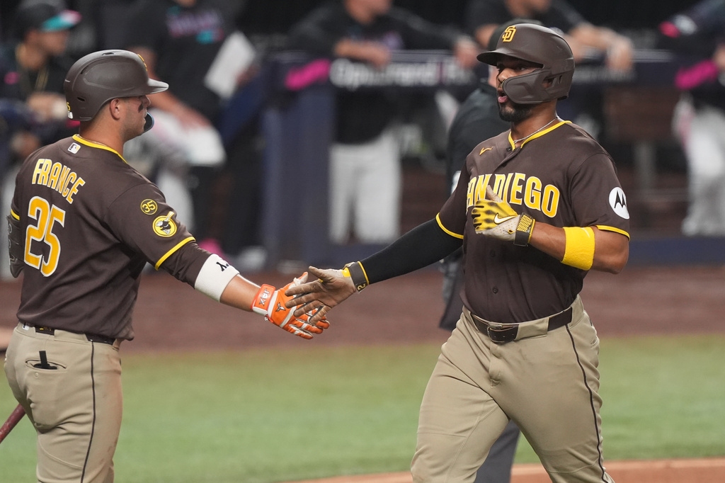 San Diego Padres' Xander Bogaerts, right, scored on a an fielding error during the fifth inning of a baseball game against the Miami Marlins Friday, July 24, 2026, in Miami. (AP Photo/Marta Lavandier)