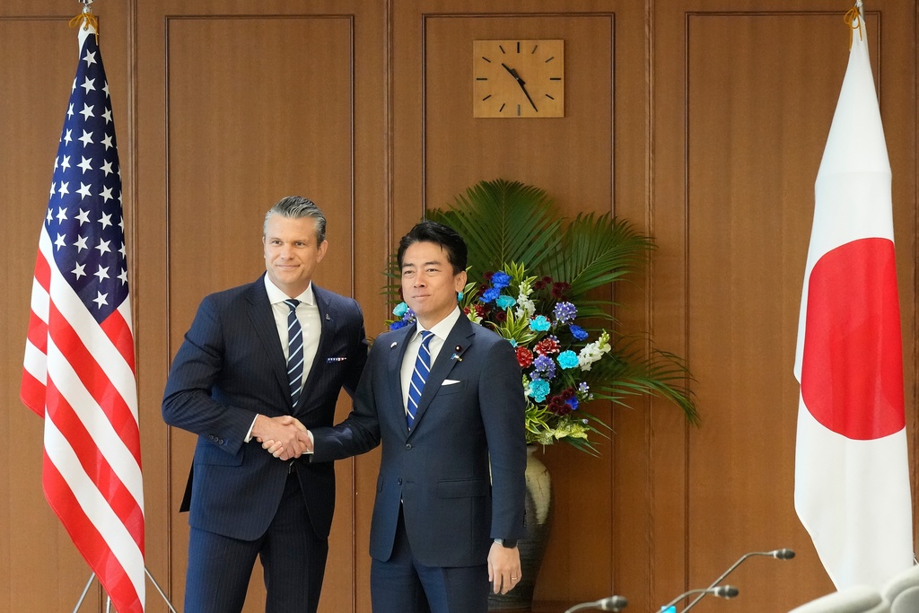 Japan's Defense Minister Shinjiro Koizumi, right, and U.S. Defense Secretary Pete Hegseth shake hands before their meeting at the Japanese defense ministry in Tokyo Wednesday, Oct. 29, 2025. (AP Photo/Eugene Hoshiko, Pool)