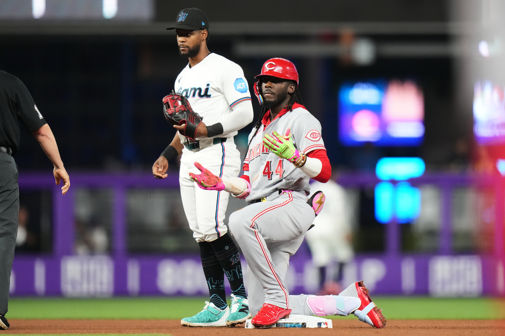 Cincinnati Reds shortstop Elly de la Cruz, right, reacts after hitting a double during the fourth inning of a baseball game against the Miami Marlins, Monday, April 6, 2026, in Miami. (AP Photo/Lynne Sladky)