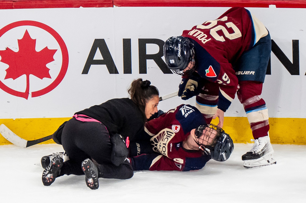 Montreal Victoire's Laura Stacey, center, lays on the ice injured as teammate Marie-Philip Poulin, right, and medical staff attend to her during the third period of a PWHL playoff hockey game in Laval, Quebec, Thursday, May 14, 2026. (Christopher Katsarov/The Canadian Press via AP)