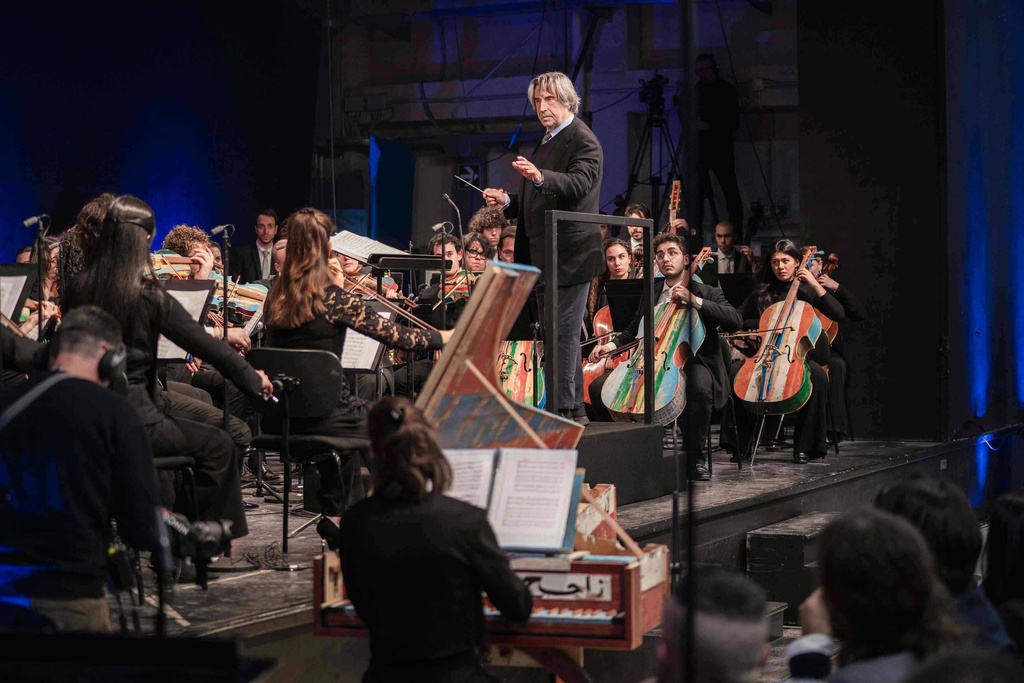 This image, distributed on Monday, Jan. 12, 2026, by Fondazione Casa Dello Spirito e delle Arti, shows conductor Riccardo Muti performing with the Orchestra del Mare using musical instruments made from the timber of sunken migrant ships inside the Opera Prison in Milan, northern Italy, on Saturday, Jan. 10, 2026. (Marco Borrelli/Fondazione Casa Dello Spirito e delle Arti via AP, HO)