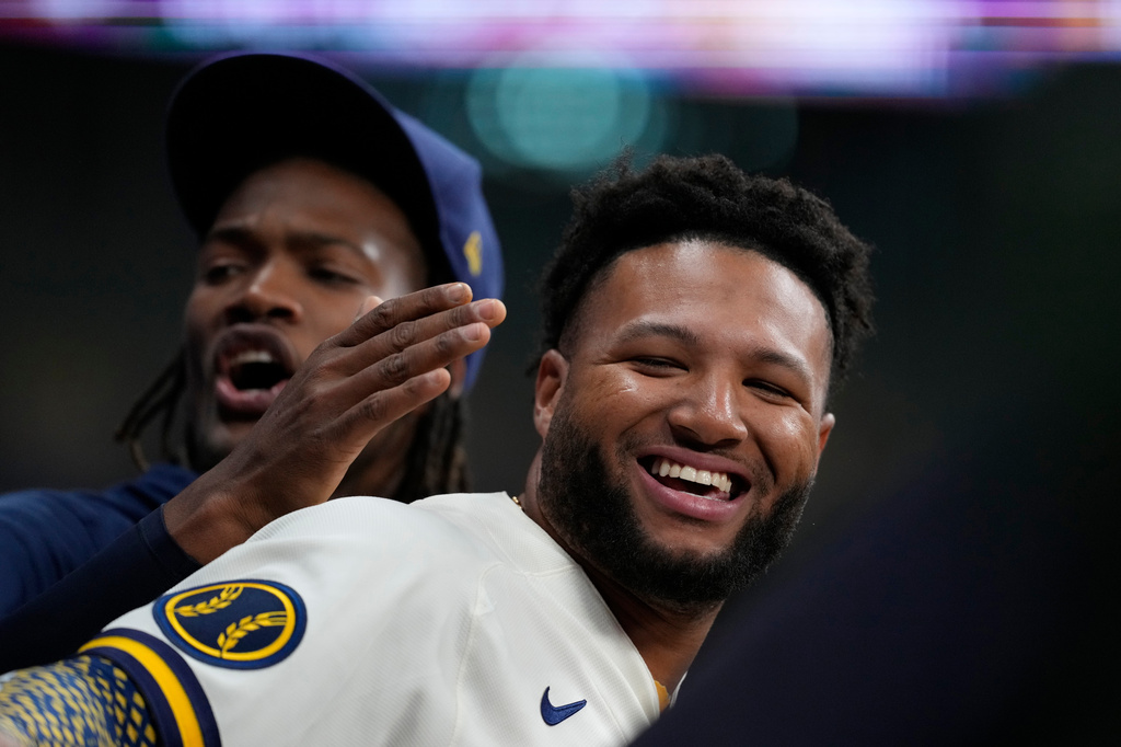 Milwaukee Brewers' Jackson Chourio, right, laughs with Abner Uribe in the dugout during the eighth inning of a baseball game against the San Francisco Giants, Tuesday, June 2, 2026, in Milwaukee. (AP Photo/Aaron Gash)