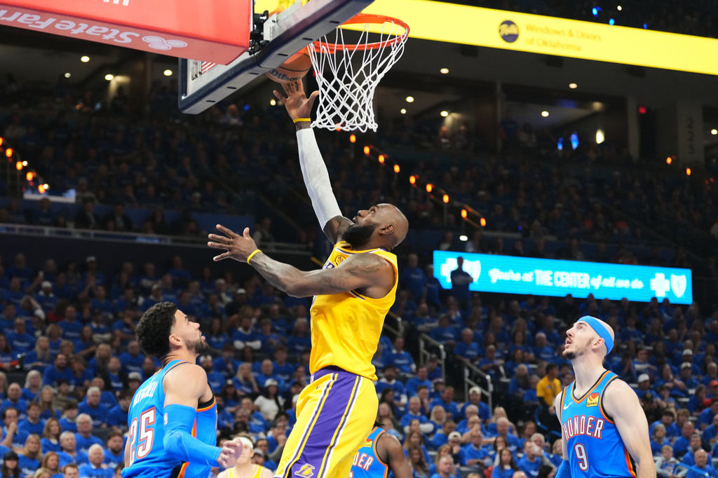 Los Angeles Lakers forward LeBron James shoots between Oklahoma City Thunder's Ajay Mitchell (25) and Alex Caruso (9) in the first half of Game 1 in a second-round NBA basketball playoffs series Tuesday, May 5, 2026 in Oklahoma City. (AP Photo/Kyle Phillips)