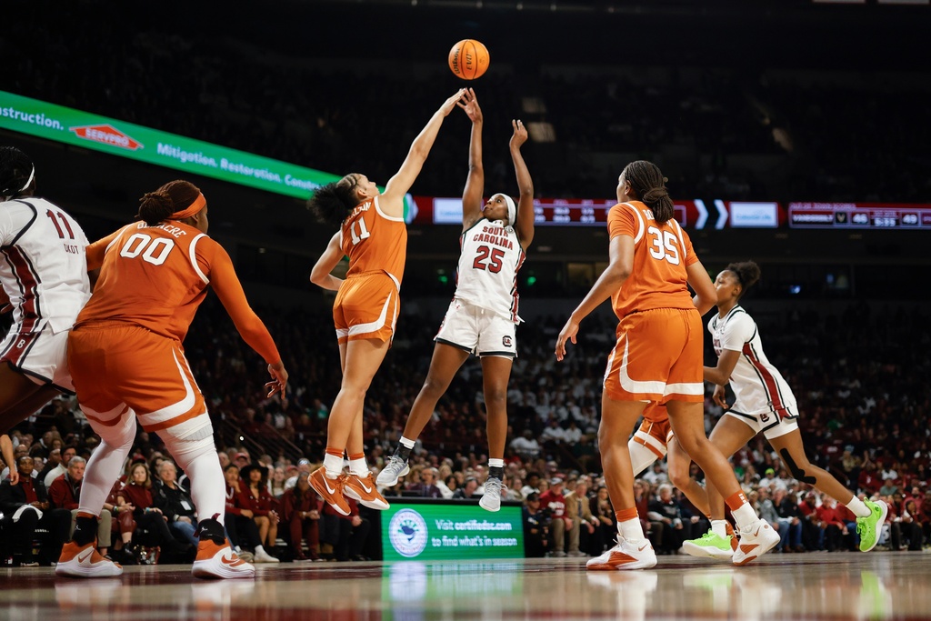 South Carolina guard Raven Johnson (25) shoots over Texas forward Justice Carlton (11) as center Kyla Oldacre (00) and forward Madison Booker (35) look on during the first half of an NCAA college basketball game in Columbia, S.C., Thursday, Jan. 15, 2026. (AP Photo/Nell Redmond)