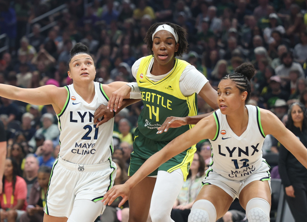 Seattle Storm center Dominique Malonga (14) is defended by Minnesota Lynx forward Nia Coffey, right and guard Kayla McBride during the first half of a WNBA basketball game Monday, July 20, 2026, in Seattle. (Dean Rutz/The Seattle Times via AP)