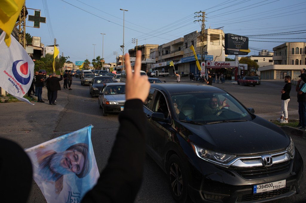 Displaced residents drive back to their villages as locals wave Hezbollah flags and an image of late Hezbollah leader Hassan Nasrallah, in Zefta, southern Lebanon, Friday, April 17, 2026, following a ceasefire between Israel and Hezbollah. (AP Photo/Hassan Ammar)