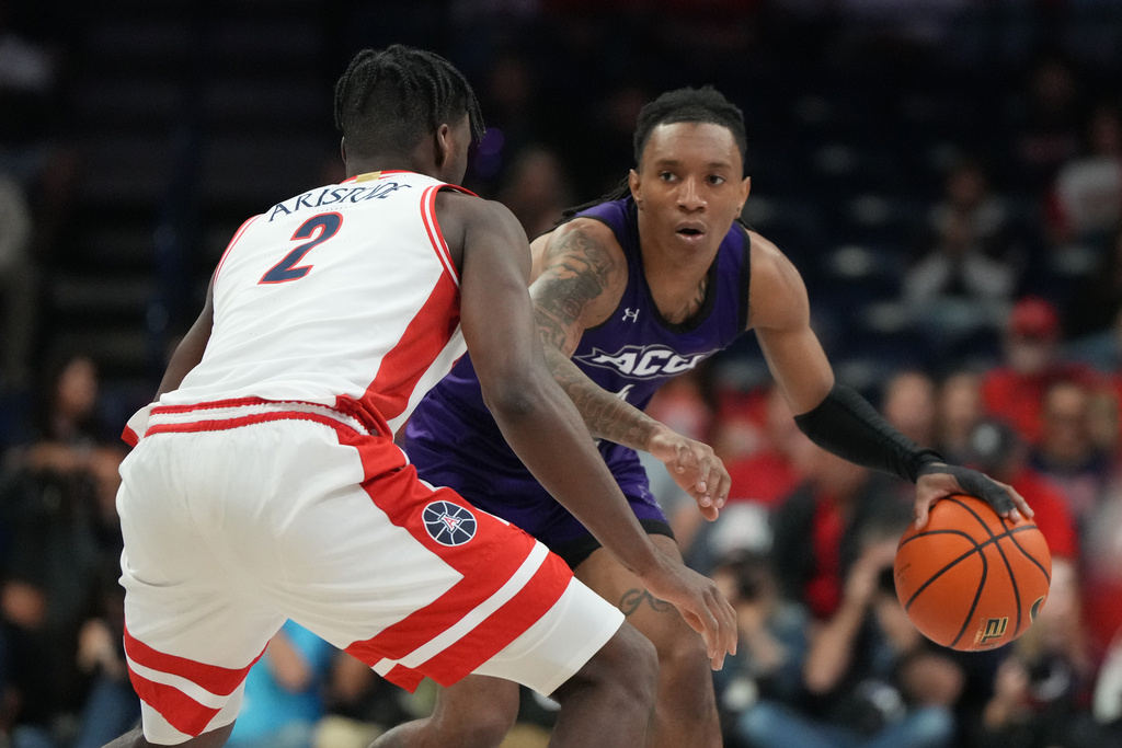 Abilene Christian guard Rich Smith drives on Arizona guard Dwayne Aristode (2) during the first half of an NCAA college basketball game, Tuesday, Dec. 16, 2025, in Tucson, Ariz. (AP Photo/Rick Scuteri)
