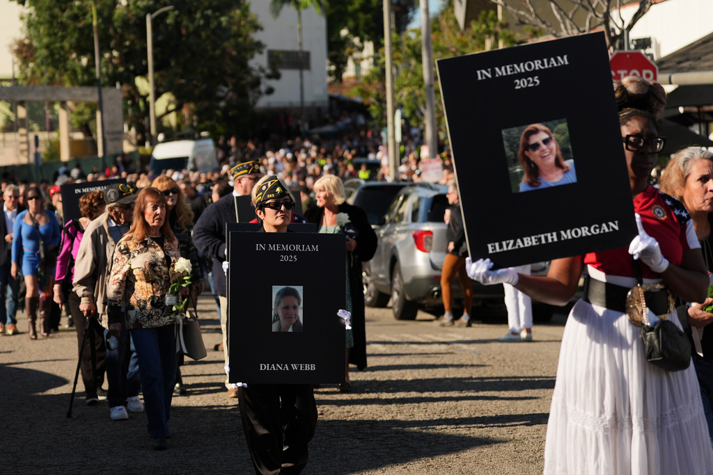 Photo of victims are carried in a procession on the one-year anniversary of the Palisades Fire in the Pacific Palisades neighborhood of Los Angeles Wednesday, Jan. 7, 2026. (AP Photo/Jae C. Hong)