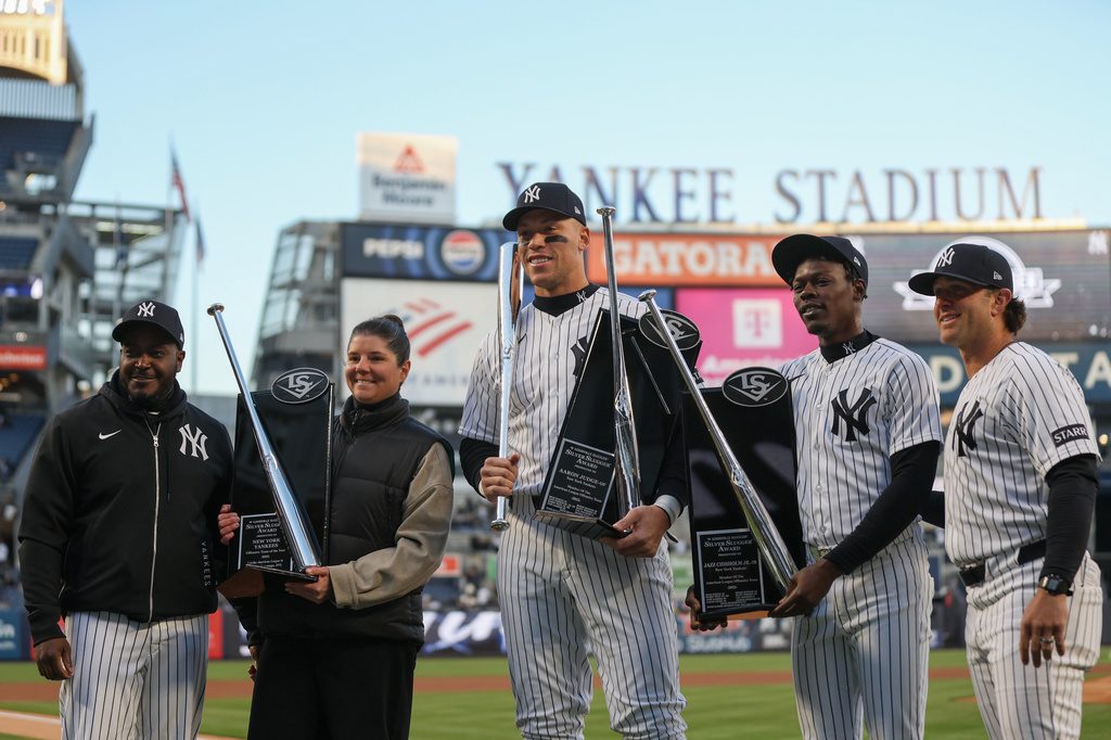 New York Yankees coaches and players including outfielder Aaron Judge, center, and second baseman Jazz Chisholm Jr., center right, receive their Silver Slugger awards before a baseball game against the Athletics, Wednesday, April 8, 2026, in New York. (AP Photo/Heather Khalifa)