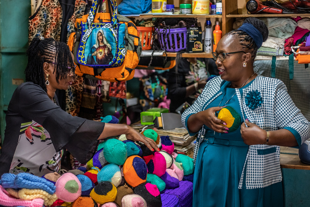 Nancy Waithera, right, tries on a knitted breast prosthesis as Mary Mwangi, 52, looks on at her shop in Thika, Kiambu County, Kenya, Friday, Jan. 30, 2026. (AP Photo/Samson Otieno)