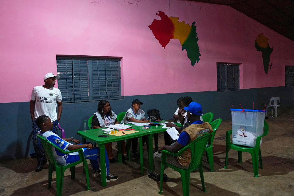 Officials wait at a polling station as polls close during the constitutional referendum in Conakry, Guinea, Sunday, Sept. 21, 2025. (AP Photo/Misper Apawu)