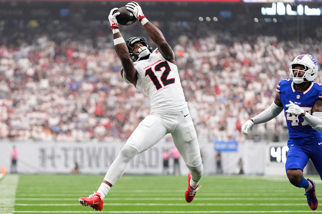 Houston Texans wide receiver Nico Collins (12) catches a pass as Buffalo Bills cornerback Christian Benford (47) defends during the first half of an NFL football game, Sunday, Sept. 13, 2026, in Houston. (AP Photo/Ashley Landis)