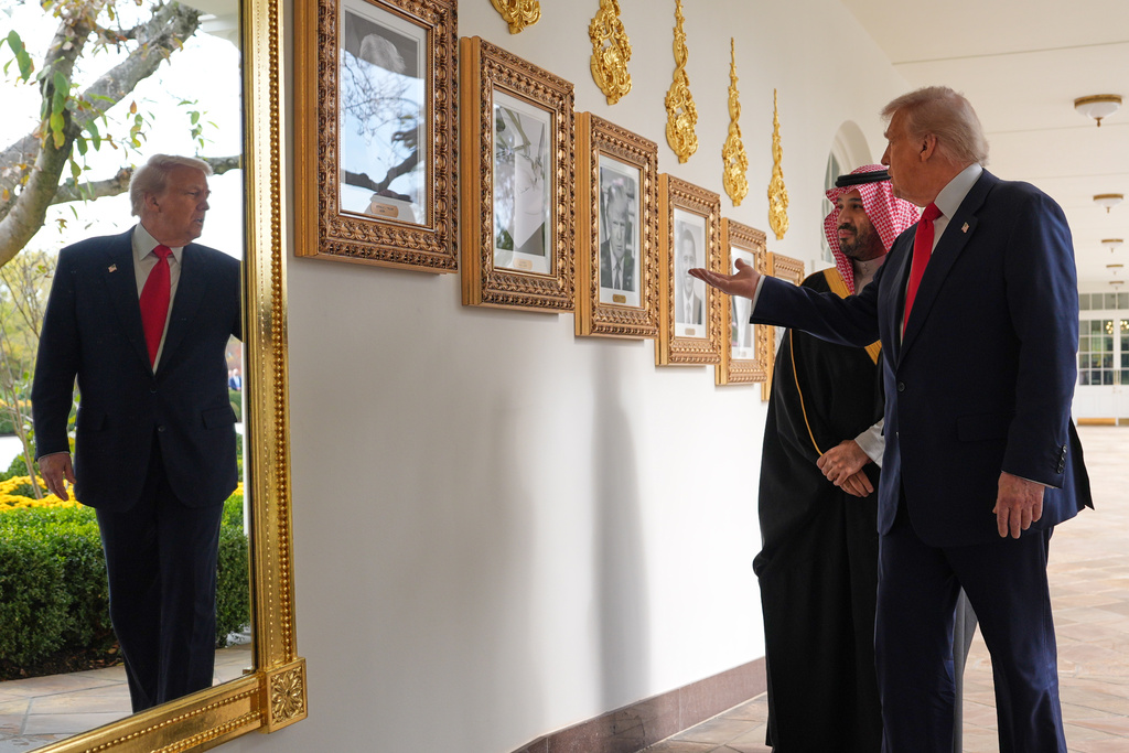 President Donald Trump shows Saudi Arabia's Crown Prince Mohammed bin Salman portraits of former president as they walk along the Colonnade at the White House, Tuesday, Nov. 18, 2025, in Washington. (AP Photo/Evan Vucci)