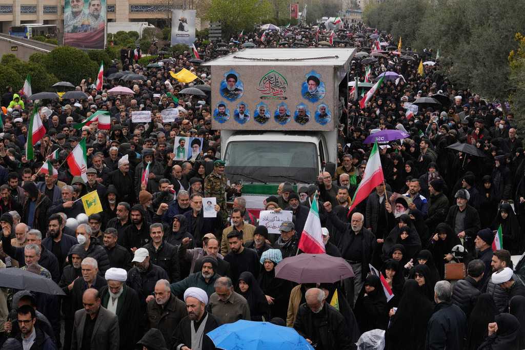 Iranians follow a truck carrying the coffins of Iran's intelligence minister Esmail Khatib and, according to Iranian officials, his wife and daughter, during a funeral procession in Tehran, Iran, Friday, March 20, 2026. (AP Photo/Vahid Salemi)