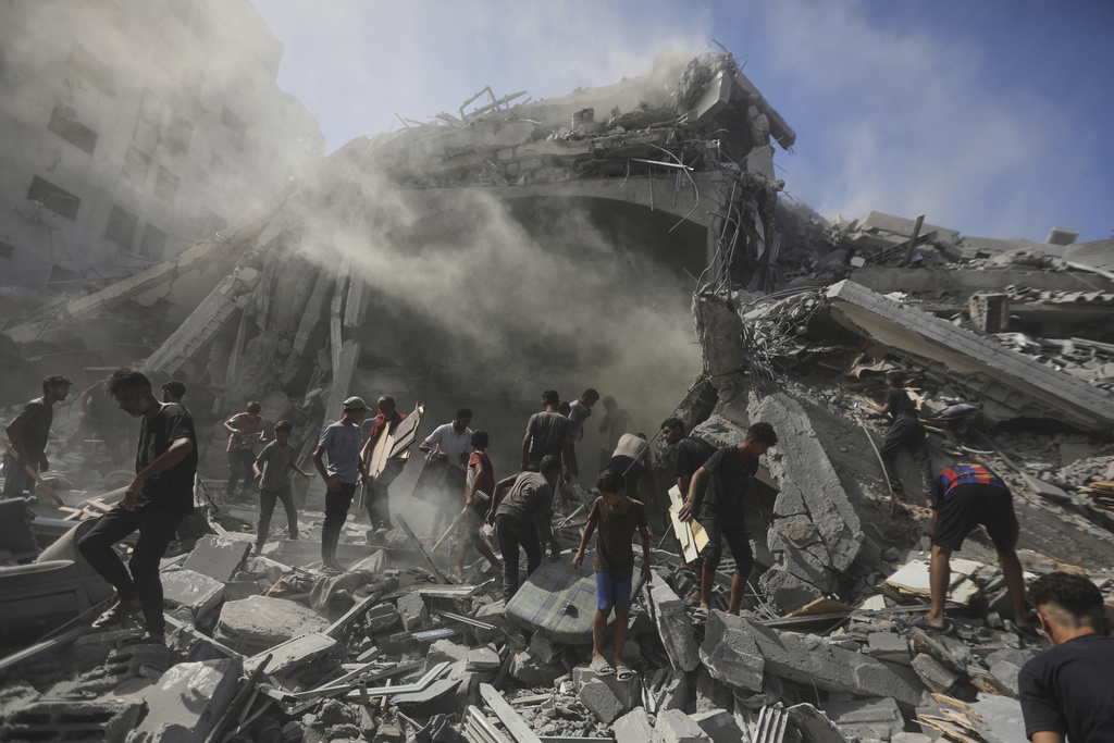 Palestinians search for wood to sell or use for cooking amid the rubble of a building hit by an Israeli strike in Gaza City, Sunday, Sept. 14, 2025. (AP Photo/Yousef Al Zanoun)