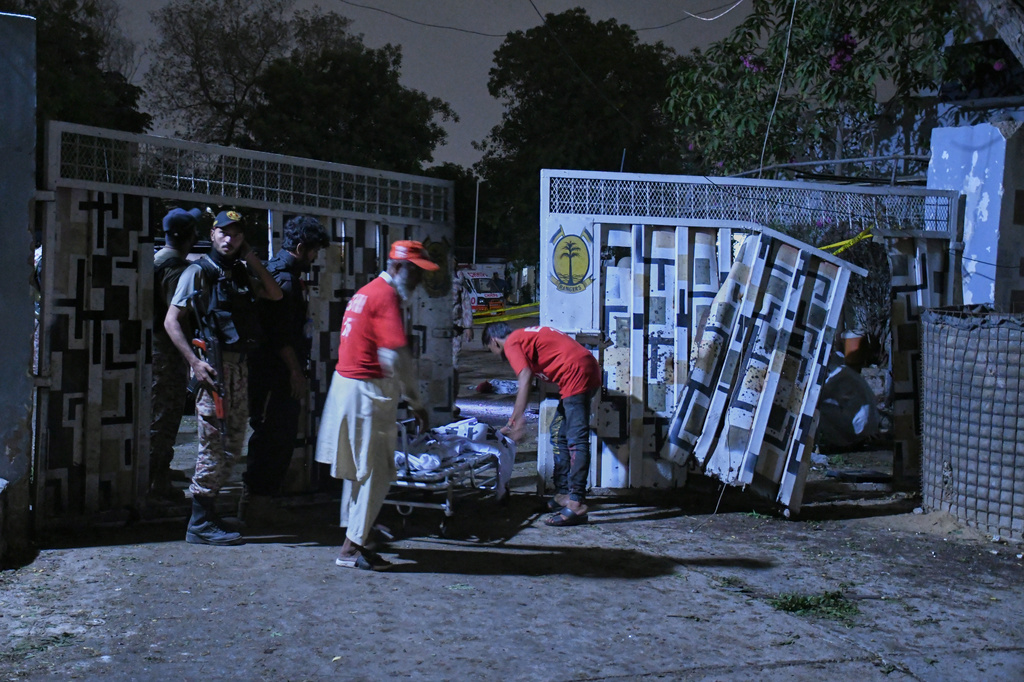 Rescue workers remove a body in Karachi, Pakistan, Sunday, June 28, 2026. (AP Photo/Ali Raza)