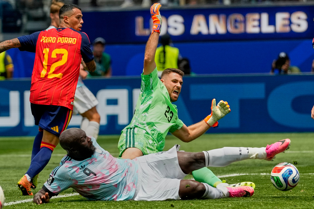 Belgium's Romelu Lukaku (9) falls as he attempts to score past Spain goalkeeper Unai Simon (23), during the World Cup quarterfinal soccer match between Spain and Belgium in Inglewood, Calif., near Los Angeles, Friday, July 10, 2026. (AP Photo/Andre Penner)