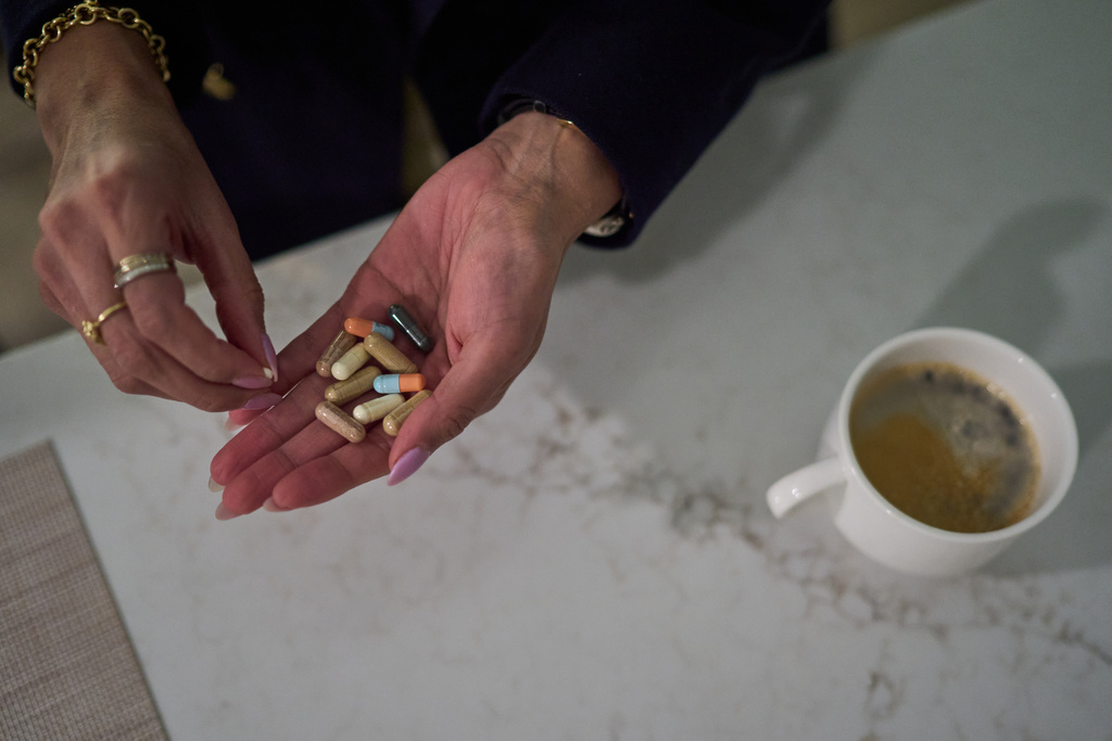 Ruth Wilson, whose has lupus, takes her prescription medications and supplements before going to work on Jan. 13, 2025, in Littleton, Mass. (AP Photo/David Goldman)