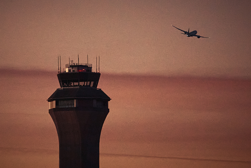 FILE - A plane flies by a control tower at Newark Liberty International Airport on Nov. 7, 2025, in Newark, N.J. (AP Photo/Andres Kudacki, File)