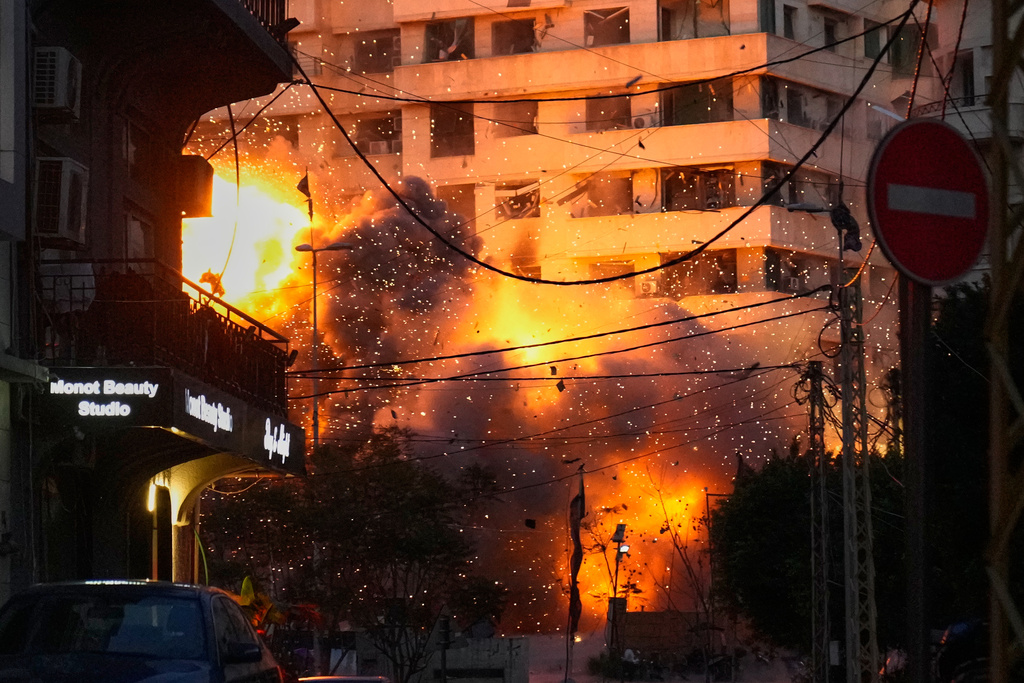 An explosion erupts from a building following an Israeli strike in central Beirut, Lebanon, Wednesday, March 18, 2026. (AP Photo/Hussein Malla)