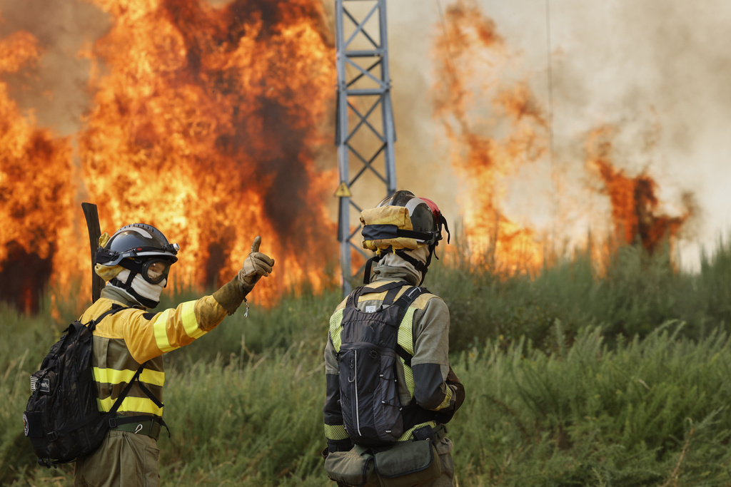 Firefighters battle a wildfire in Veiga das Meas, northwestern Spain, Saturday, Aug. 16, 2025. (AP Photo/Lalo R. Villar)