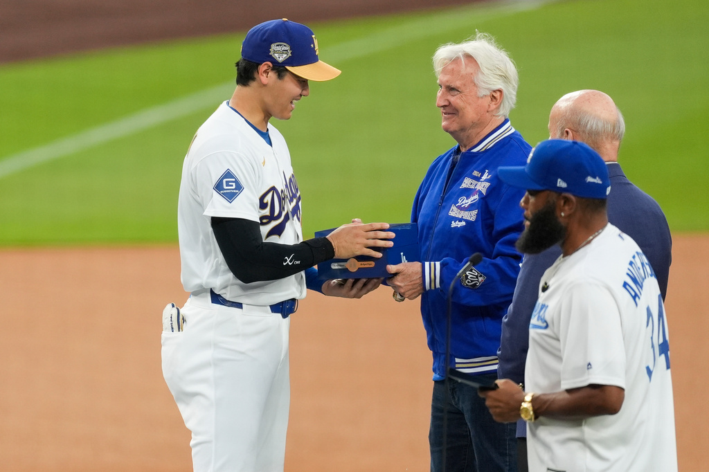 Los Angeles Dodgers Shohei Ohtani receives his ring from Los Angeles Dodgers owner Mark Walter during a World Series Champion ring ceremony prior to a baseball game against the Arizona Diamondbacks in Los Angeles, Friday, March 27, 2026. (AP Photo/Caroline Brehman)