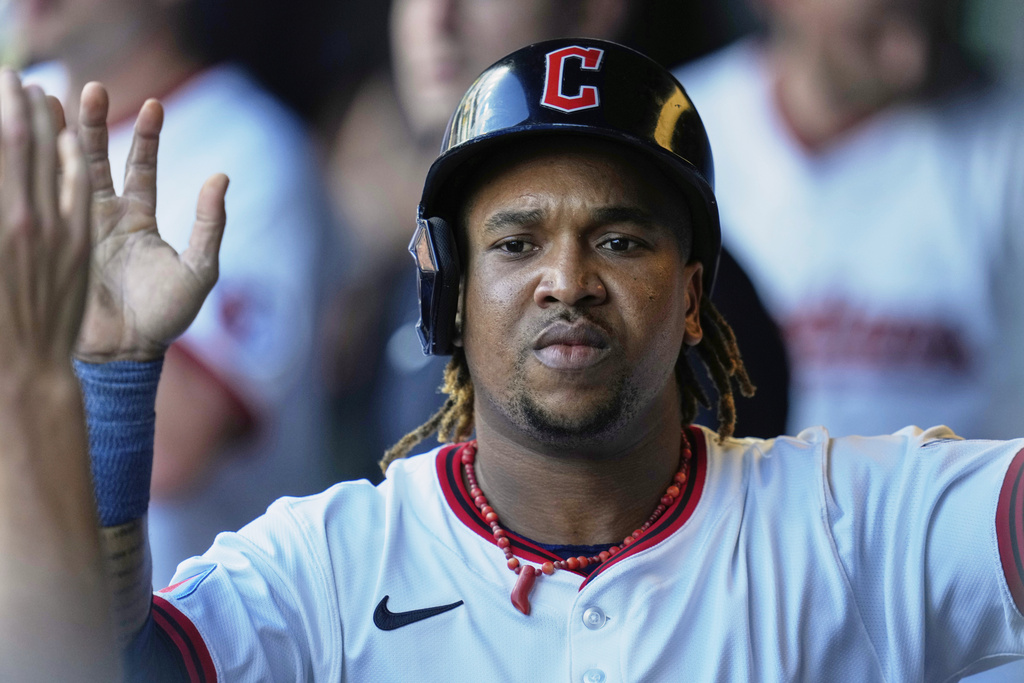 Cleveland Guardians' Jose Ramirez is congratulated in the dugout after scoring in the first inning of a baseball game against the Miami Marlins in Cleveland, Thursday, Aug. 14, 2025. (AP Photo/Sue Ogrocki)