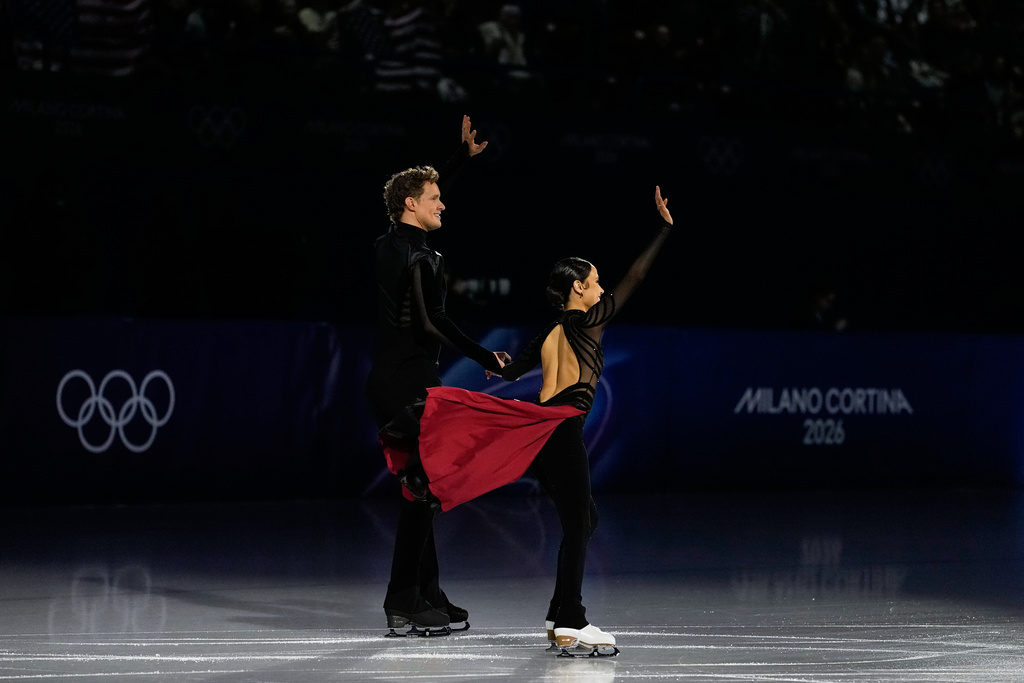Madison Chock and Evan Bates of the United States wave to the crowd before the figure skating ice dance team event at the 2026 Winter Olympics, in Milan, Italy, Saturday, Feb. 7, 2026. (AP Photo/Natacha Pisarenko)
