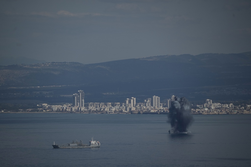 An incoming projectile explodes over the water as Israel issues a nationwide alert following its strikes on Iran, in Haifa Bay, northern Israel, Saturday, Feb. 28, 2026. (AP Photo/Leo Correa)