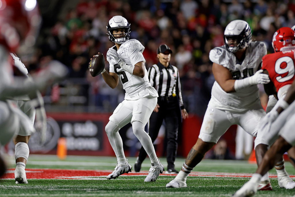 Oregon quarterback Dante Moore (5) looks to pass the ball during the first half of an NCAA college football game against Rutgers, Saturday, Oct. 18, 2025, in Piscataway, N.J. (AP Photo/Adam Hunger)