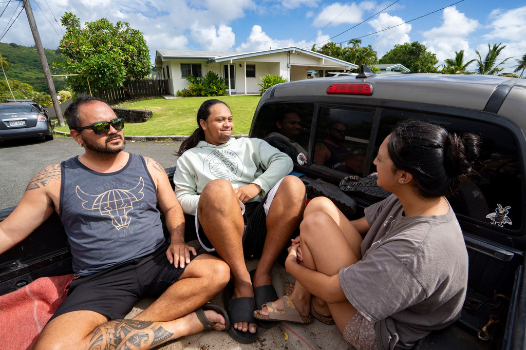 Kimeona Kane rides with his nephew, Gabriel Shimaoka, and niece, Genesis Shimaoka, in the bed of his pickup truck, Friday, July 17, 2026, in Kailua, Hawaii. (AP Photo/Mengshin Lin)