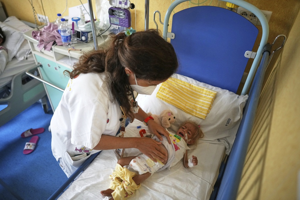 Shamm Qudeih, 2, receives medical care from Dr. Margherita Rosa at the Santobono Pausilipon Children's Hospital in Naples, southern Italy, Tuesday, Sept. 2, 2025, where she is being treated after being evacuated from Gaza. (AP Photo/Andrew Medichini)