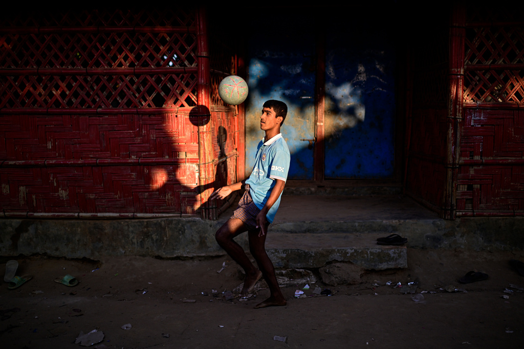 A Rohingya refugee boy plays with a soccer ball inside a Rohingya refugee camp, home to over a million of Myanmar's persecuted Rohingya minority, in Cox's Bazar, Bangladesh, Friday, Nov. 21, 2025. (AP Photo/Mahmud Hossain Opu)