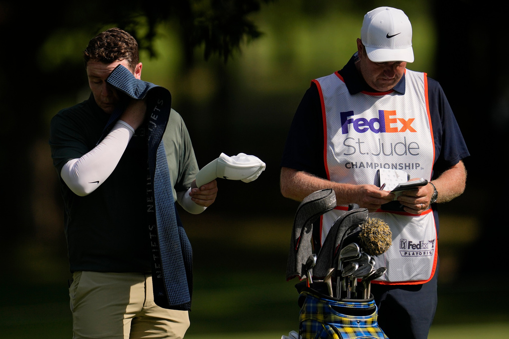 Robert MacIntyre, of Scotland, wipes his head in the heat on the fifth hole during the first round of the St. Jude Championship golf tournament, Thursday, Aug. 13, 2026, in Memphis, Tenn. (AP Photo/George Walker IV)