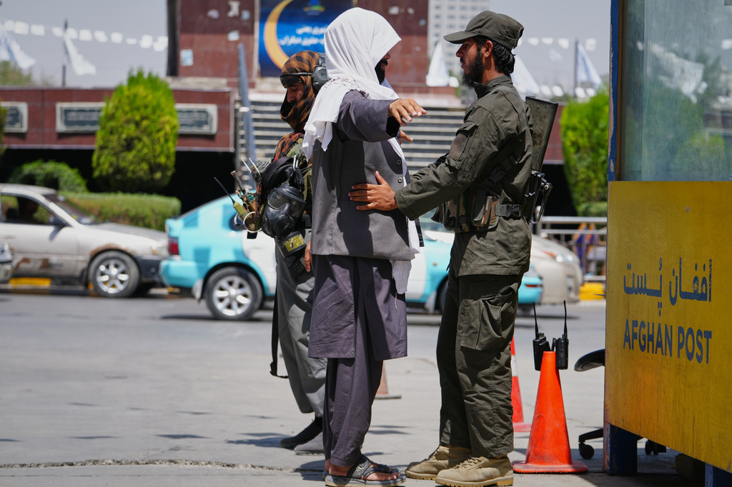A Taliban security officer searches a man at a checkpoint ahead of celebrations marking the fifth anniversary of the U.S. withdrawal from Afghanistan and the start of Taliban rule, in Kabul, Afghanistan, Thursday, Aug. 13, 2026. (AP Photo/Siddiqullah Alizai)