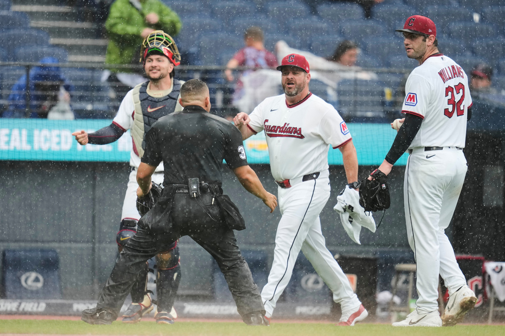 Home plate umpire Jonathan Parra (30) holds back Cleveland Guardians manager Stephen Vogt, center, between catcher Patrick Bailey, left, and pitcher Gavin Williams (32) during an argument in the sixth inning of a baseball game in Cleveland, Sunday, Aug. 2, 2026. (AP Photo/Sue Ogrocki)