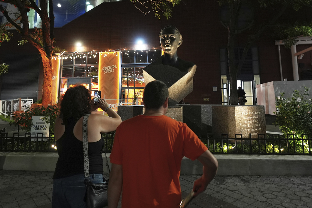 People take photos of the Althea Gibson statue outside of Arthur Ashe Stadium during the first-round of the U.S. Open tennis championships, Sunday, Aug. 24, 2025, in New York. (AP Photo/Frank Franklin II)