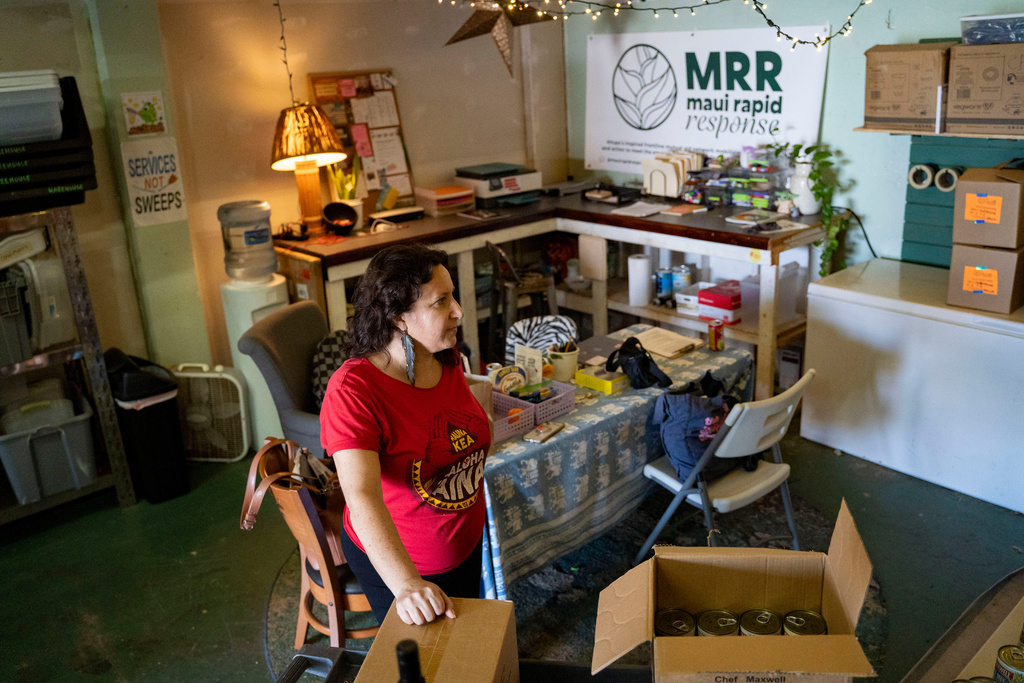 Nicole Huguenin, executive director of Maui Rapid Response, a nonprofit supporting Maui fire survivors with cash assistance, organizes canned food at the organization's warehouse in Kahului, Hawaii, Wednesday, March 4, 2026. (AP Photo/Mengshin Lin)