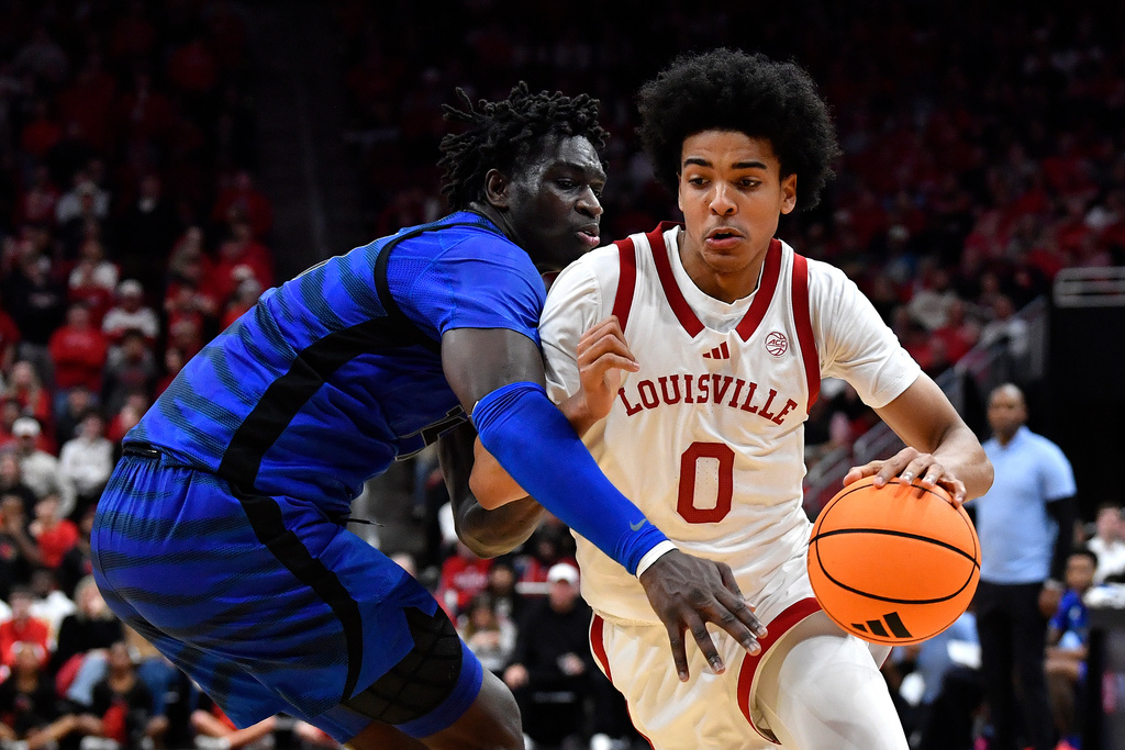 Louisville guard Mikel Brown Jr. (0) drives past Memphis guard Hasan Abdul Hakim, left, during the second half of an NCAA college basketball game in Louisville, Ky., Saturday, Dec. 13, 2025. (AP Photo/Timothy D. Easley)